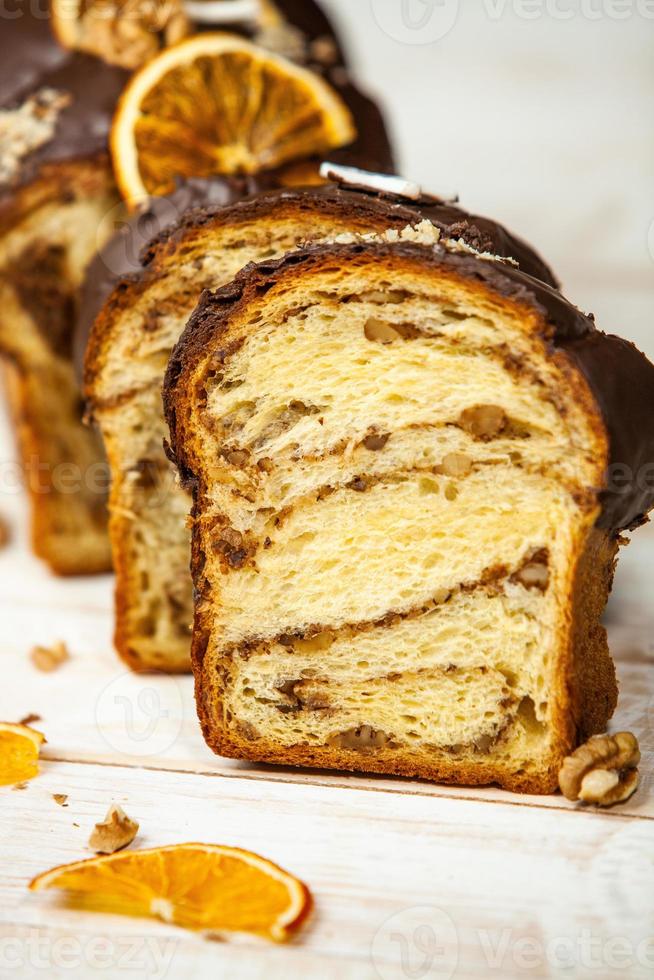 panettone casero. pan dulce tradicional italiano. panettone con una rodaja servido en una mesa de madera. foto