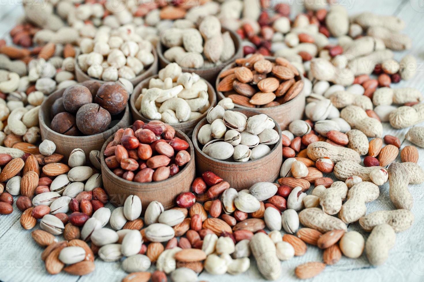 Assorted nuts for a background Almond, walnut,cashew, pistachios, hazelnuts, peanuts, Macadamia Collection of different varieties of nuts. Composition with dried fruits Healthy food. Organic. photo