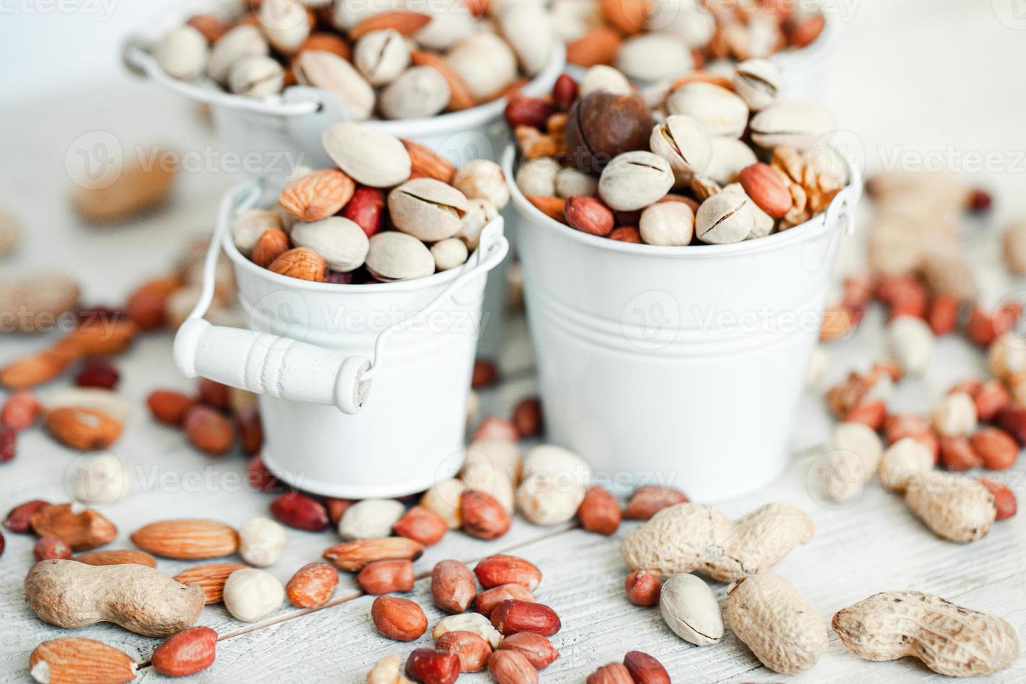 Assorted nuts for a background Almond, walnut,cashew, pistachios, hazelnuts, peanuts, Macadamia Collection of different varieties of nuts. Composition with dried fruits Healthy food. Organic. photo