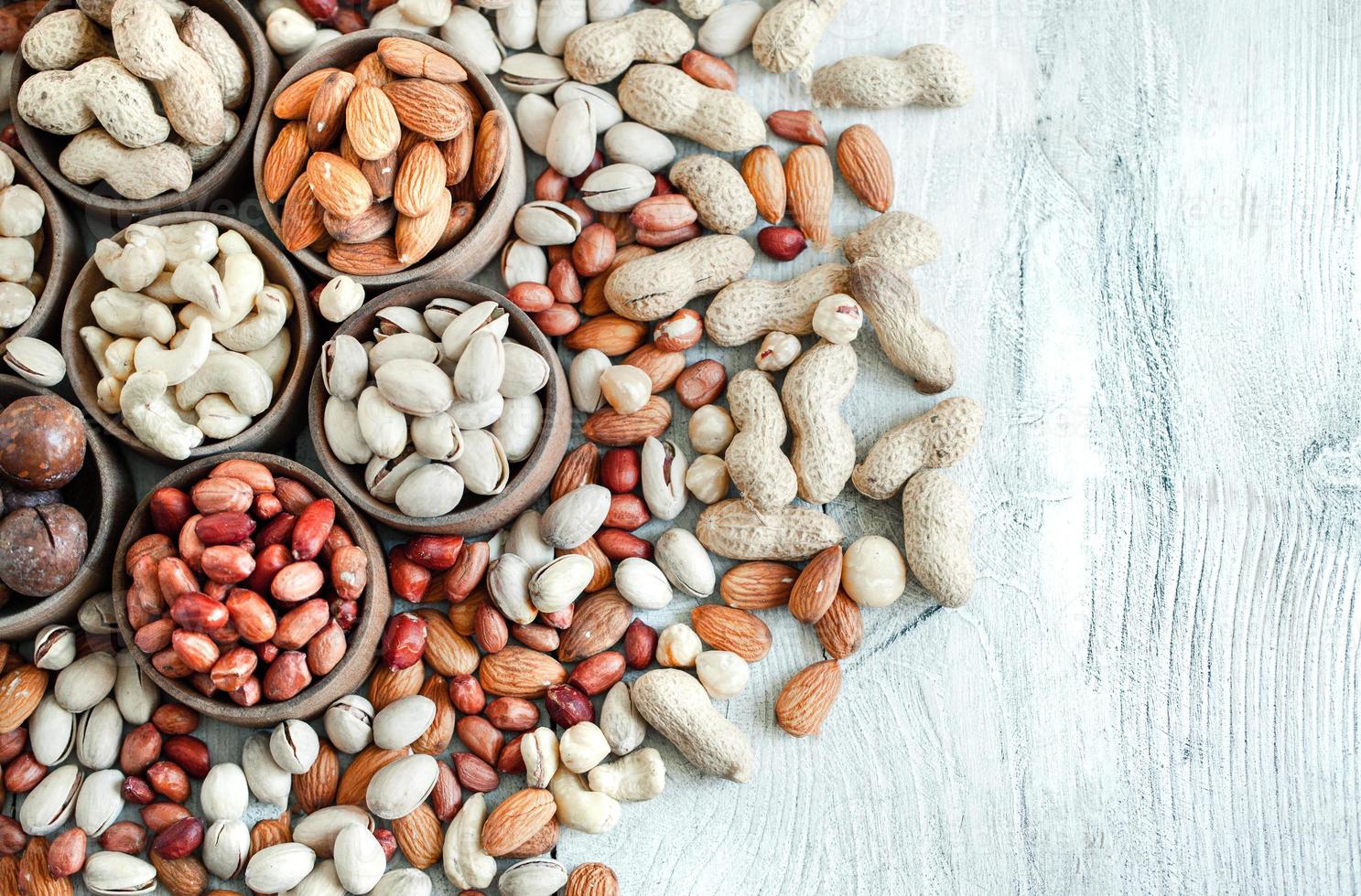 Assorted nuts for a background Almond, walnut,cashew, pistachios, hazelnuts, peanuts, Macadamia Collection of different varieties of nuts. Composition with dried fruits Healthy food. Organic. photo