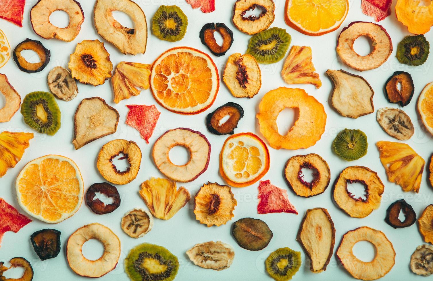 Organic Healthy Assorted Dried Fruit Mix close up. Dried fruit snacks. dried apples, mango, feijoa, dried apricots, prunes top view photo