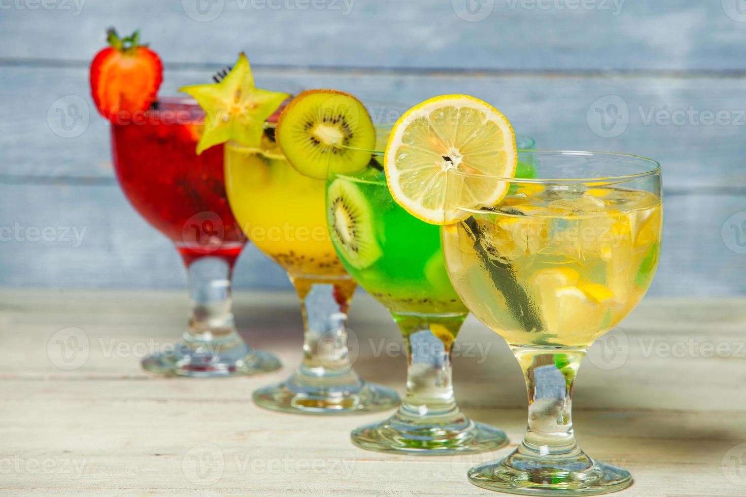 varios cócteles alcohólicos sobre fondo blanco. coloridos cócteles de cerca. bebida de cóctel de jugo de frutas. cócteles variados. vasos de bebidas de frutas con cubitos de hielo en la mesa del café foto