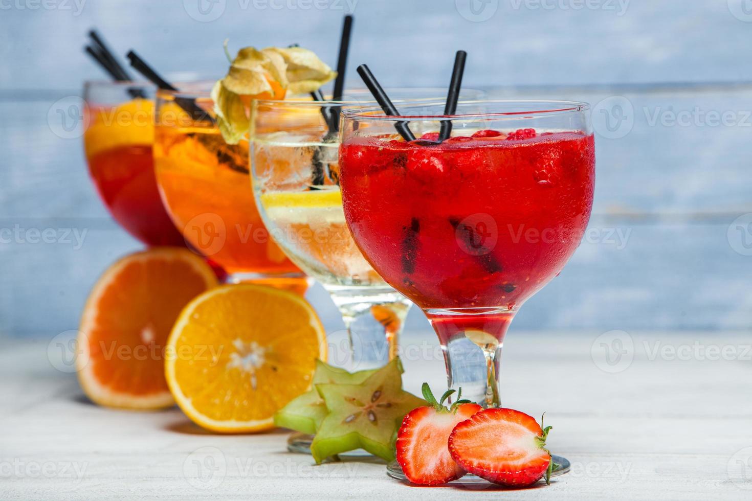 varios cócteles alcohólicos sobre fondo blanco. coloridos cócteles de cerca. bebida de cóctel de jugo de frutas. cócteles variados. vasos de bebidas de frutas con cubitos de hielo en la mesa del café foto