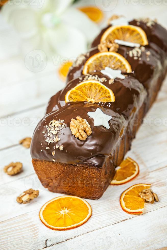 Home Made Panettone. Traditional Italian sweet bread. Panettone with a slice served on a wooden table. photo