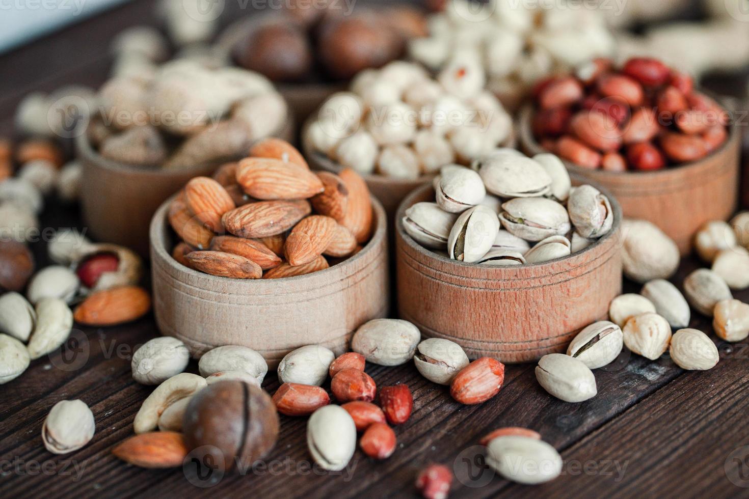 Assorted nuts for a background Almond, walnut,cashew, pistachios, hazelnuts, peanuts, Macadamia Collection of different varieties of nuts. Composition with dried fruits Healthy food. Organic. photo