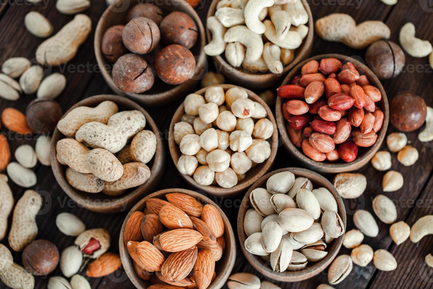 frutos secos variados para un fondo de almendras, nueces, anacardos, pistachos, avellanas, cacahuetes, macadamia colección de diferentes variedades de frutos secos. composición con frutos secos alimentos saludables. orgánico. foto