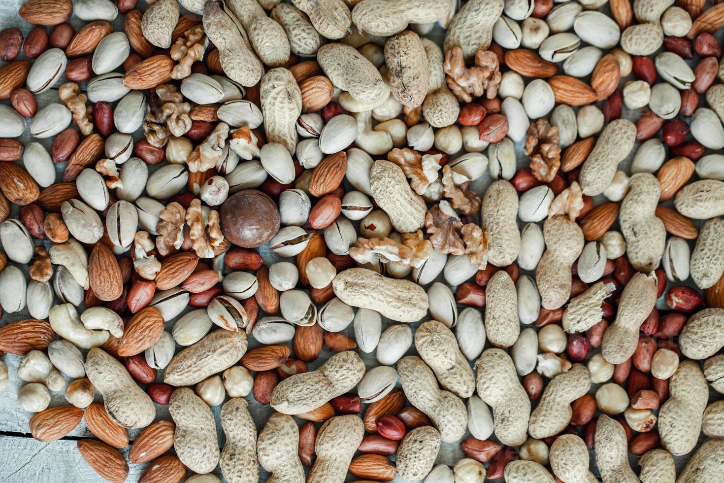 Assorted nuts for a background Almond, walnut,cashew, pistachios, hazelnuts, peanuts, Macadamia Collection of different varieties of nuts. Composition with dried fruits Healthy food. Organic. photo