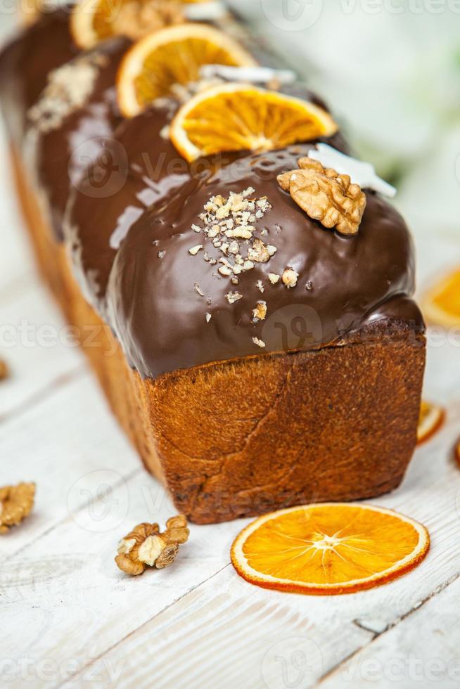 Home Made Panettone. Traditional Italian sweet bread. Panettone with a slice served on a wooden table. photo