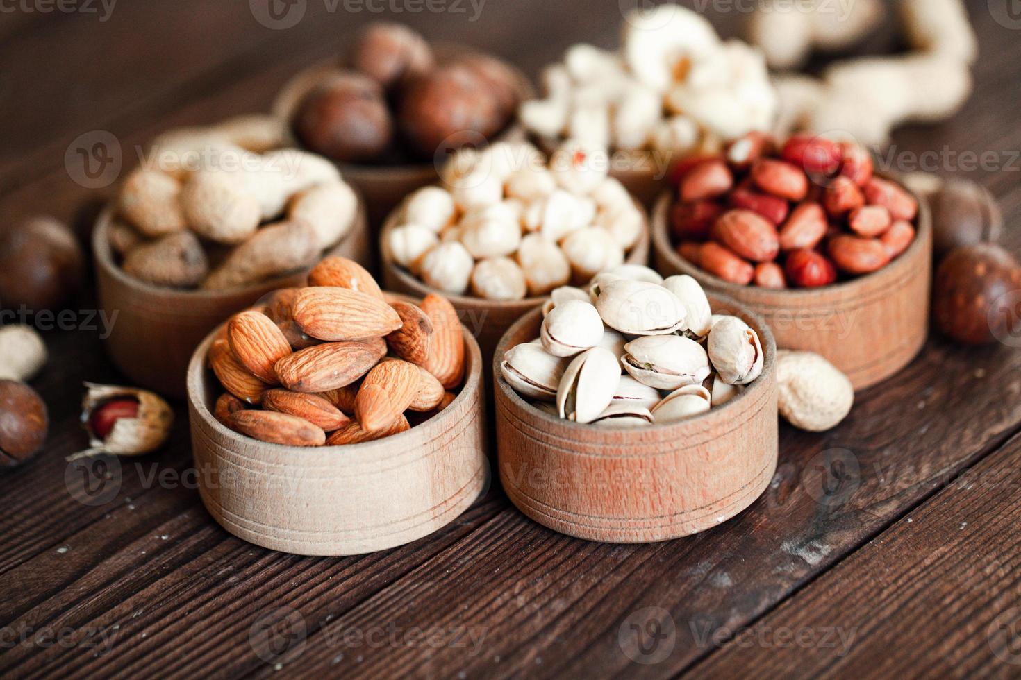 Assorted nuts for a background Almond, walnut,cashew, pistachios, hazelnuts, peanuts, Macadamia Collection of different varieties of nuts. Composition with dried fruits Healthy food. Organic. photo