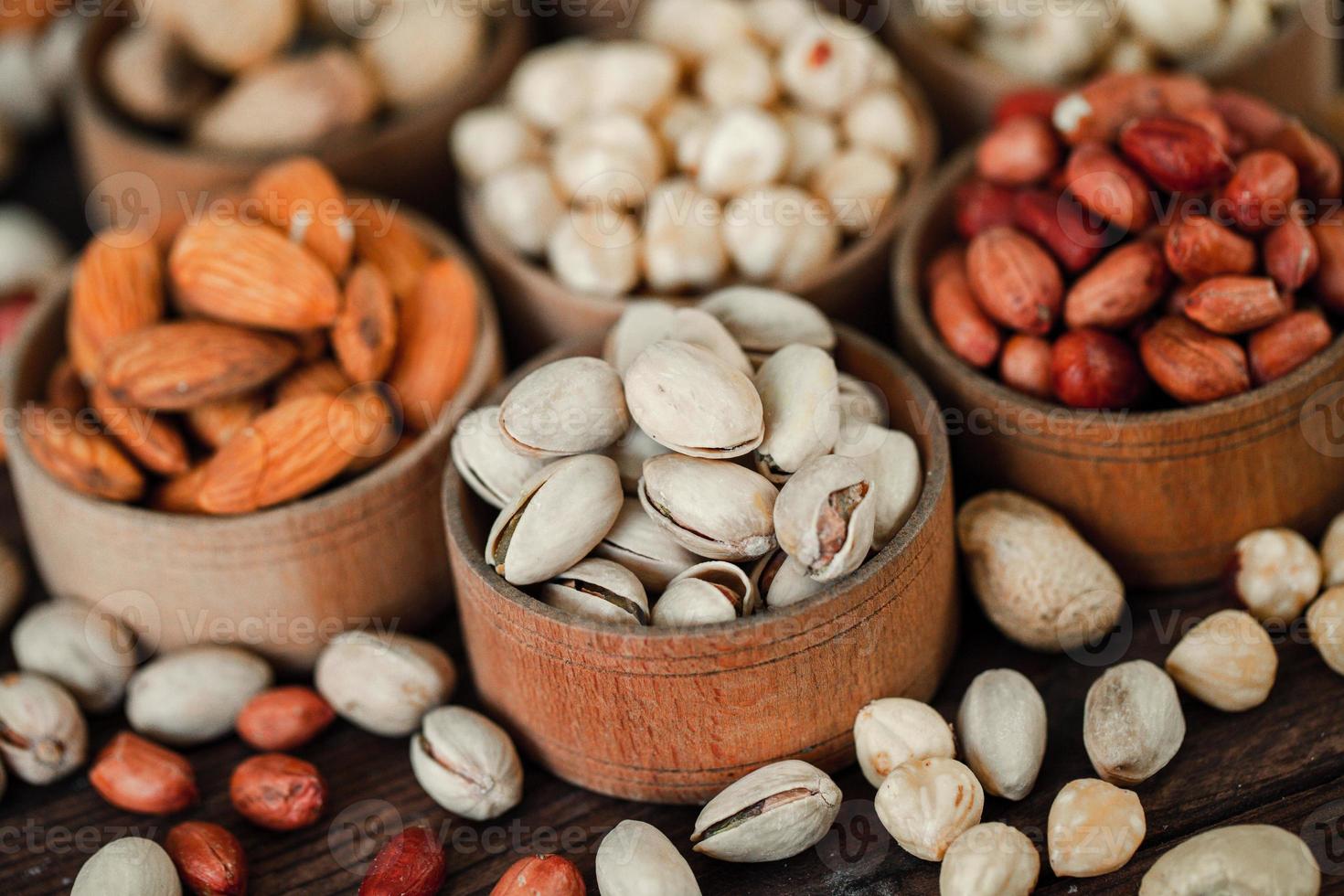 Assorted nuts for a background Almond, walnut,cashew, pistachios, hazelnuts, peanuts, Macadamia Collection of different varieties of nuts. Composition with dried fruits Healthy food. Organic. photo