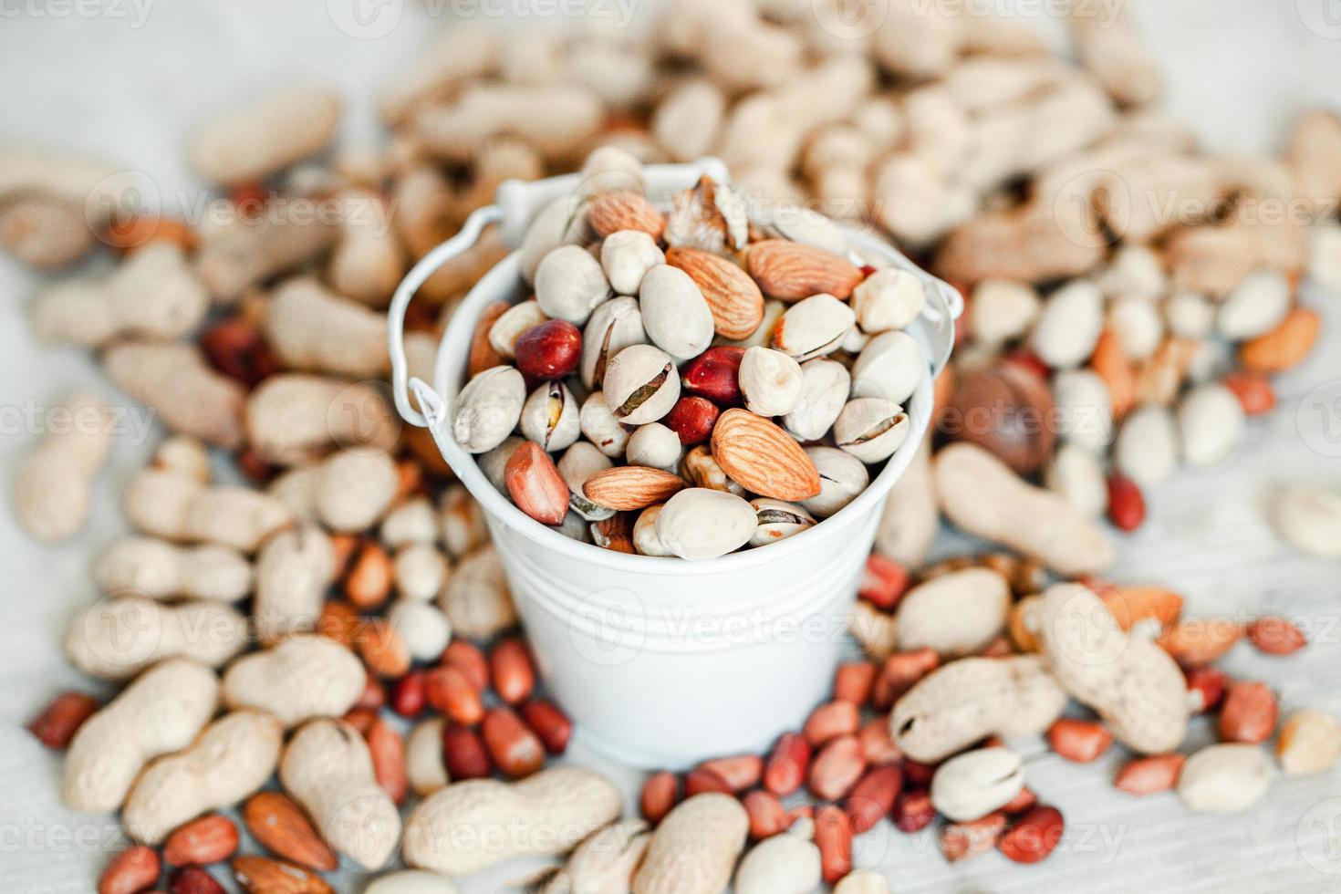 Assorted nuts for a background Almond, walnut,cashew, pistachios, hazelnuts, peanuts, Macadamia Collection of different varieties of nuts. Composition with dried fruits Healthy food. Organic. photo