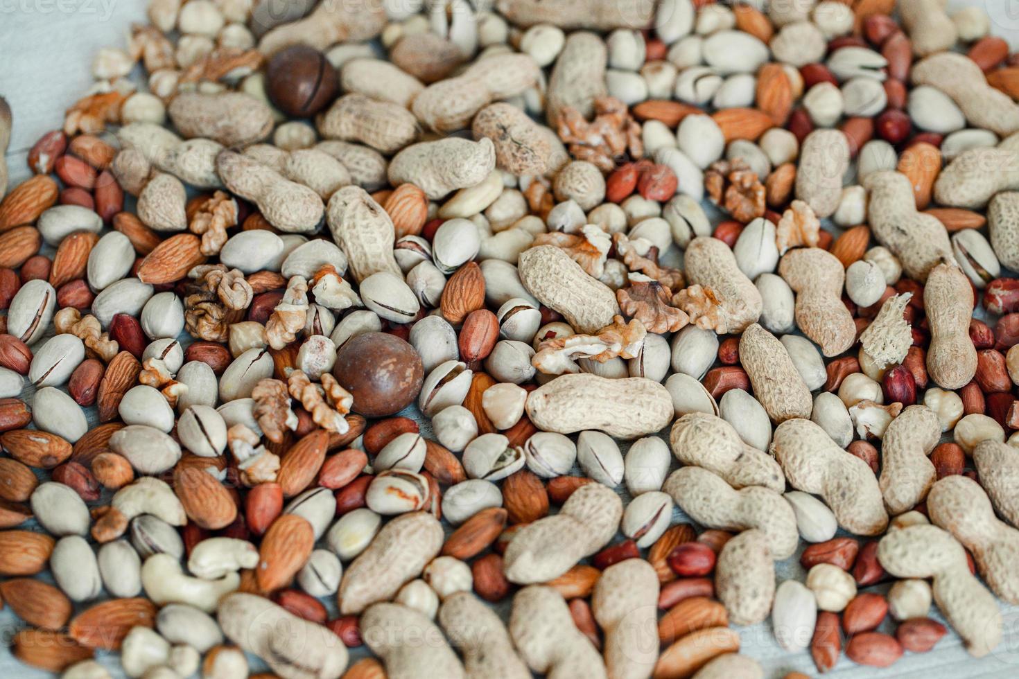 Assorted nuts for a background Almond, walnut,cashew, pistachios, hazelnuts, peanuts, Macadamia Collection of different varieties of nuts. Composition with dried fruits Healthy food. Organic. photo