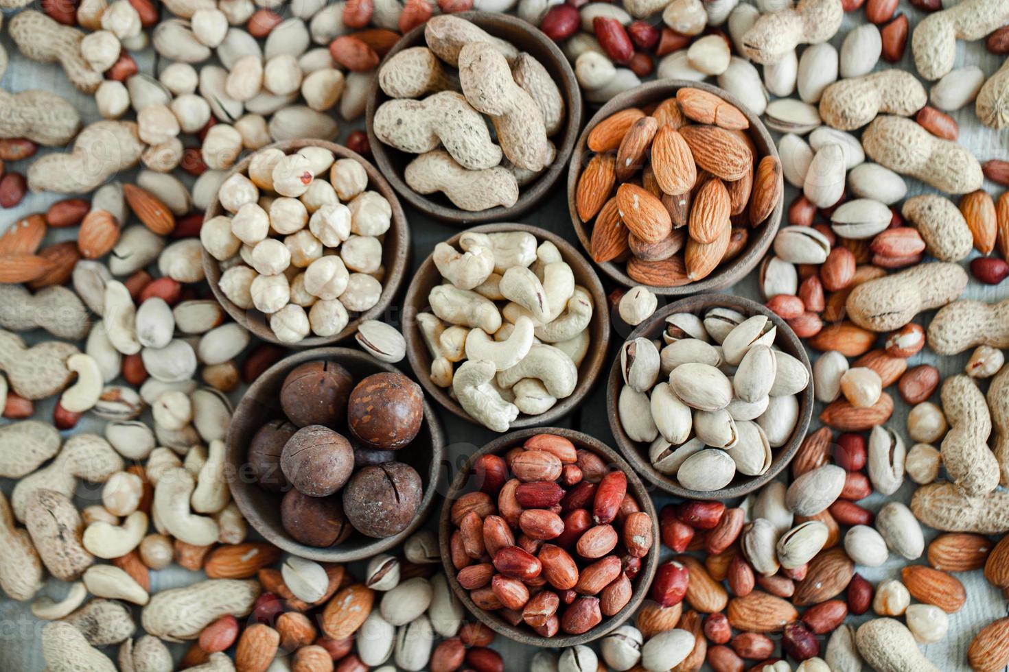 Assorted nuts for a background Almond, walnut,cashew, pistachios, hazelnuts, peanuts, Macadamia Collection of different varieties of nuts. Composition with dried fruits Healthy food. Organic. photo