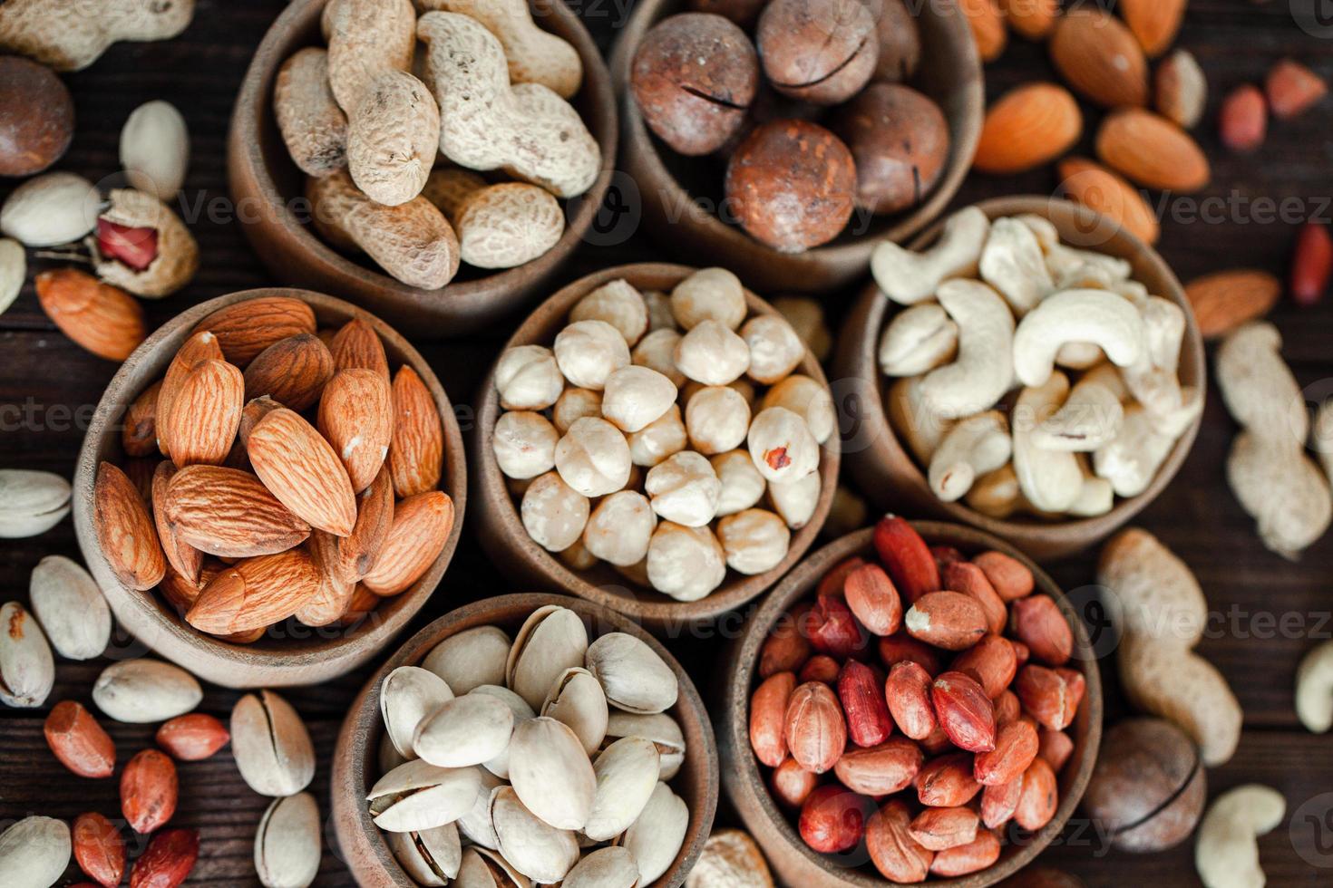 Assorted nuts for a background Almond, walnut,cashew, pistachios, hazelnuts, peanuts, Macadamia Collection of different varieties of nuts. Composition with dried fruits Healthy food. Organic. photo
