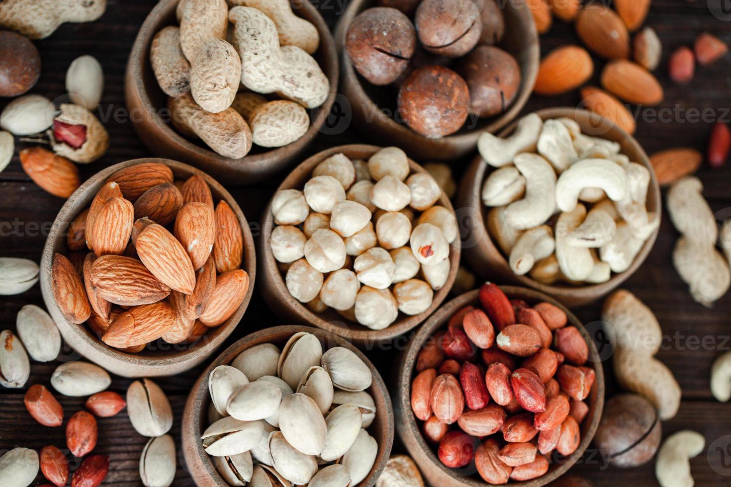 frutos secos variados para un fondo de almendras, nueces, anacardos, pistachos, avellanas, cacahuetes, macadamia colección de diferentes variedades de frutos secos. composición con frutos secos alimentos saludables. orgánico. foto