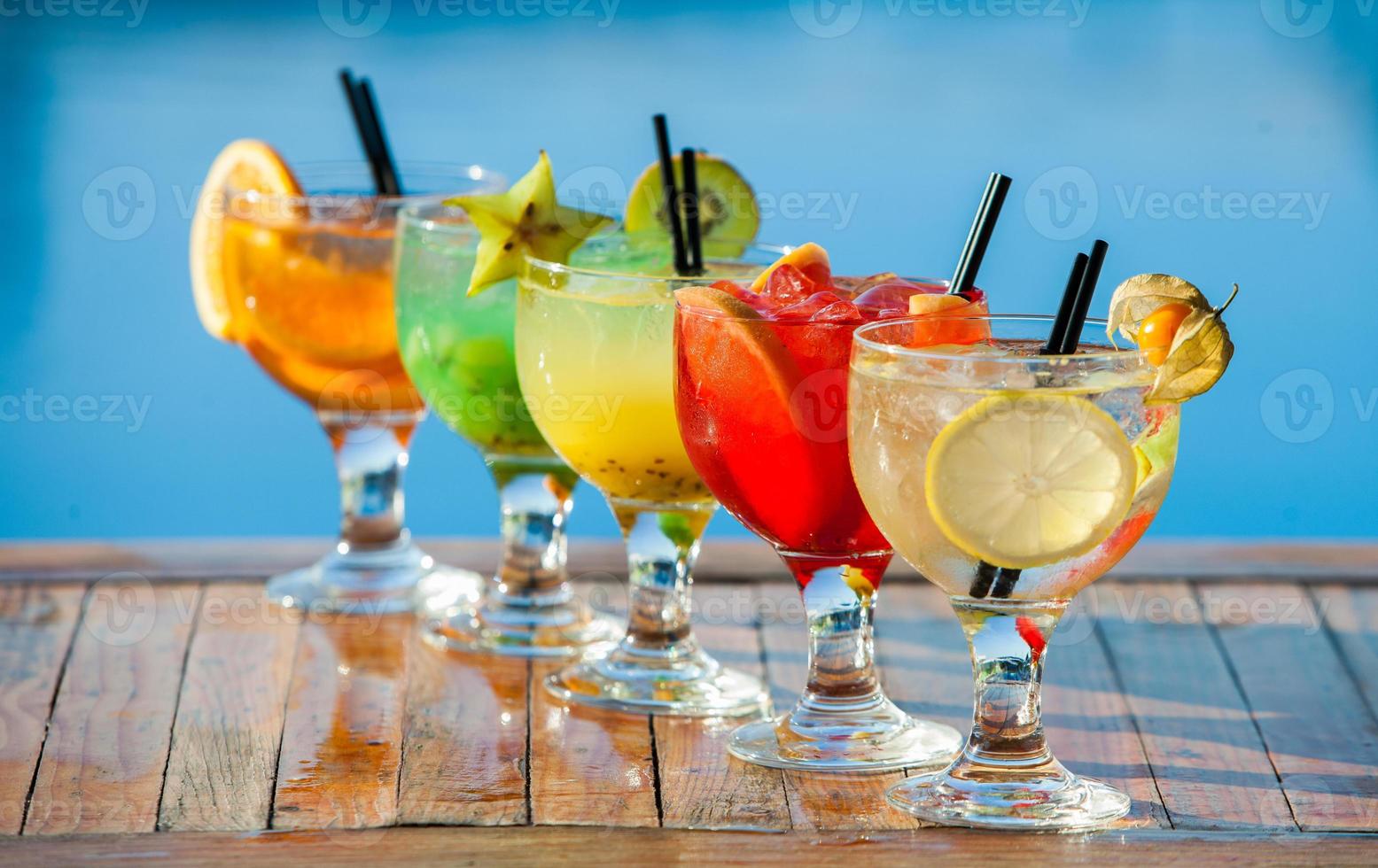 Various alcoholic cocktails on white background. Colorful cocktails close up. Fruit juice cocktail drink. assorted cocktail drinks. Glasses of fruit drinks with ice cubes on table in cafe photo