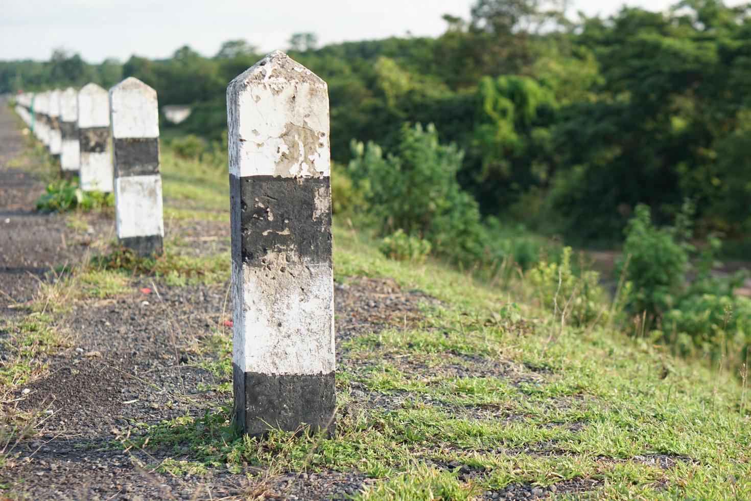 Black and white concrete pillars on the side of the road photo