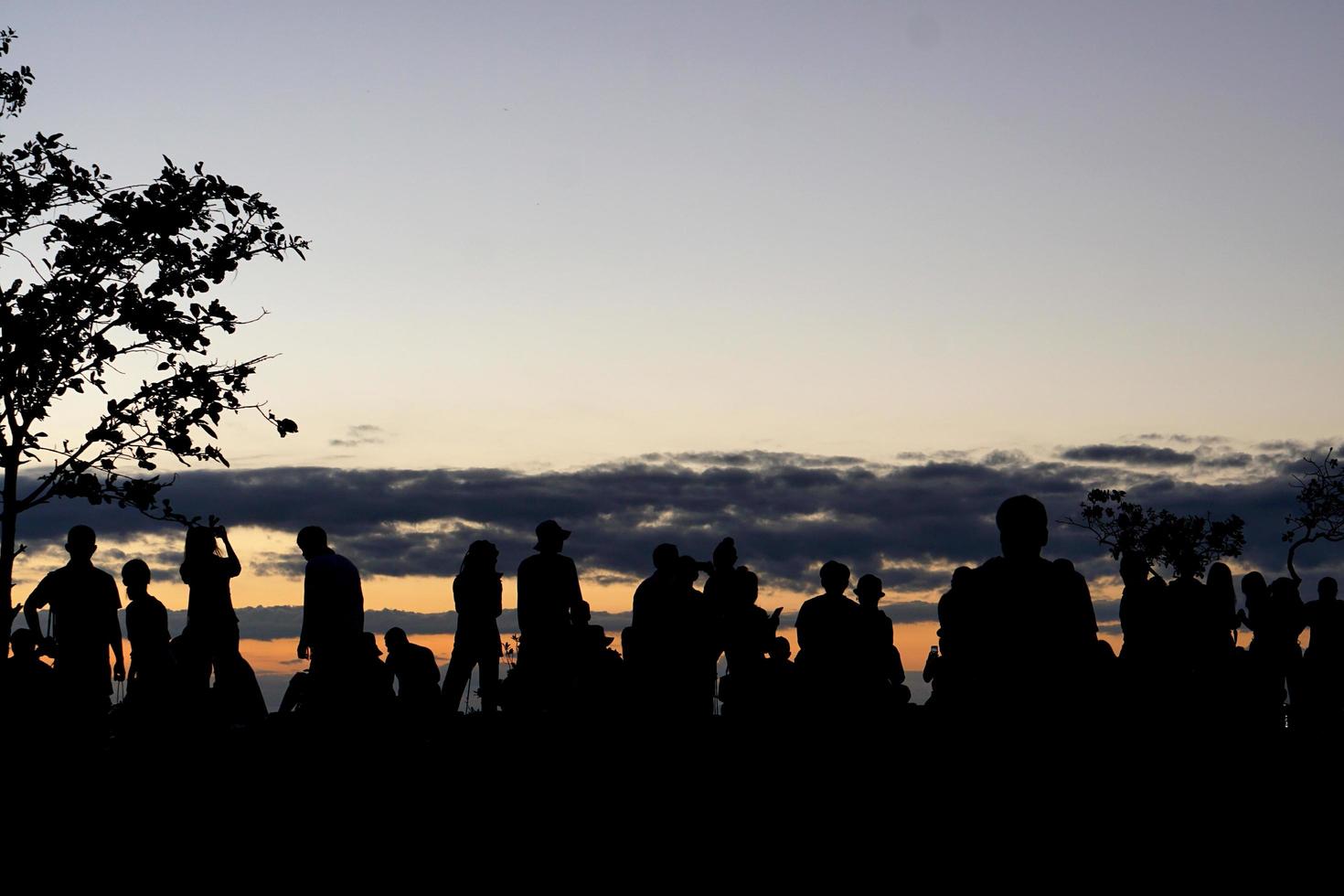 silueta de turistas esperando ver el amanecer foto