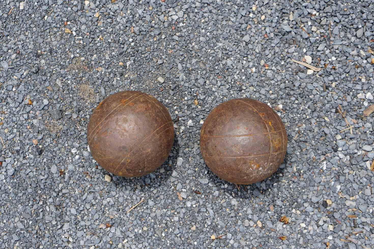 Petanque boules on a field with small stones photo