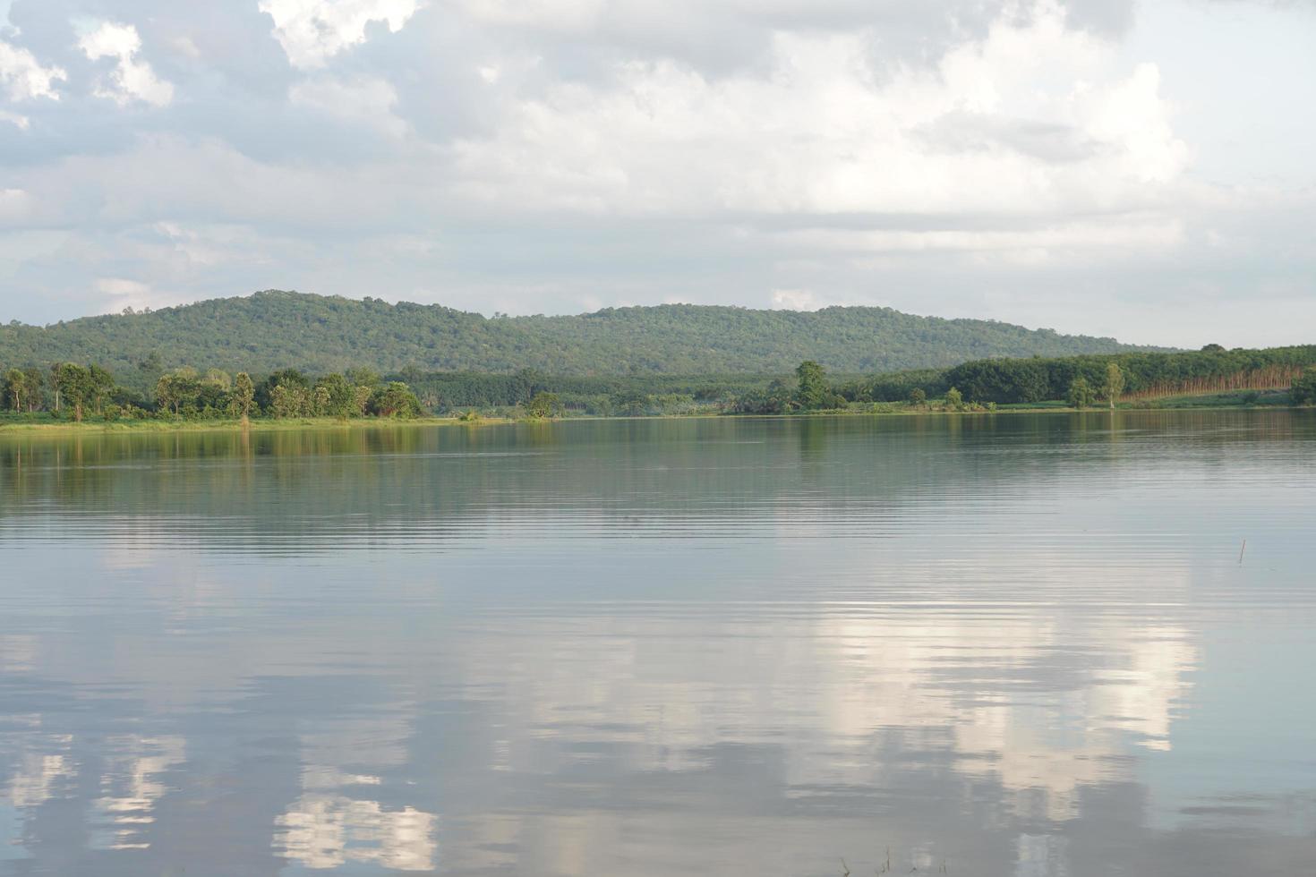 river background mountains sky clouds shadow on water surface photo