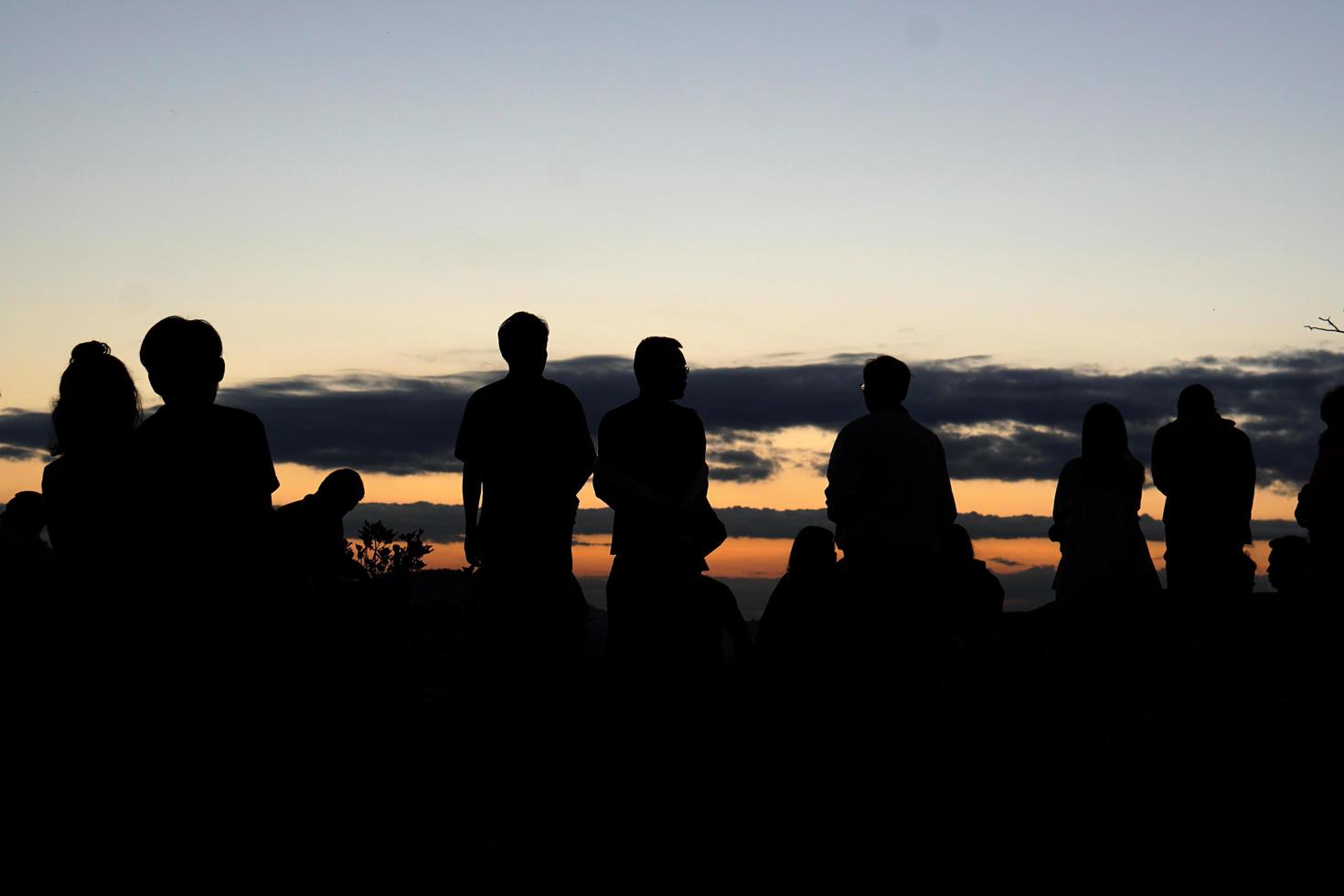 silueta de turistas esperando ver el amanecer foto