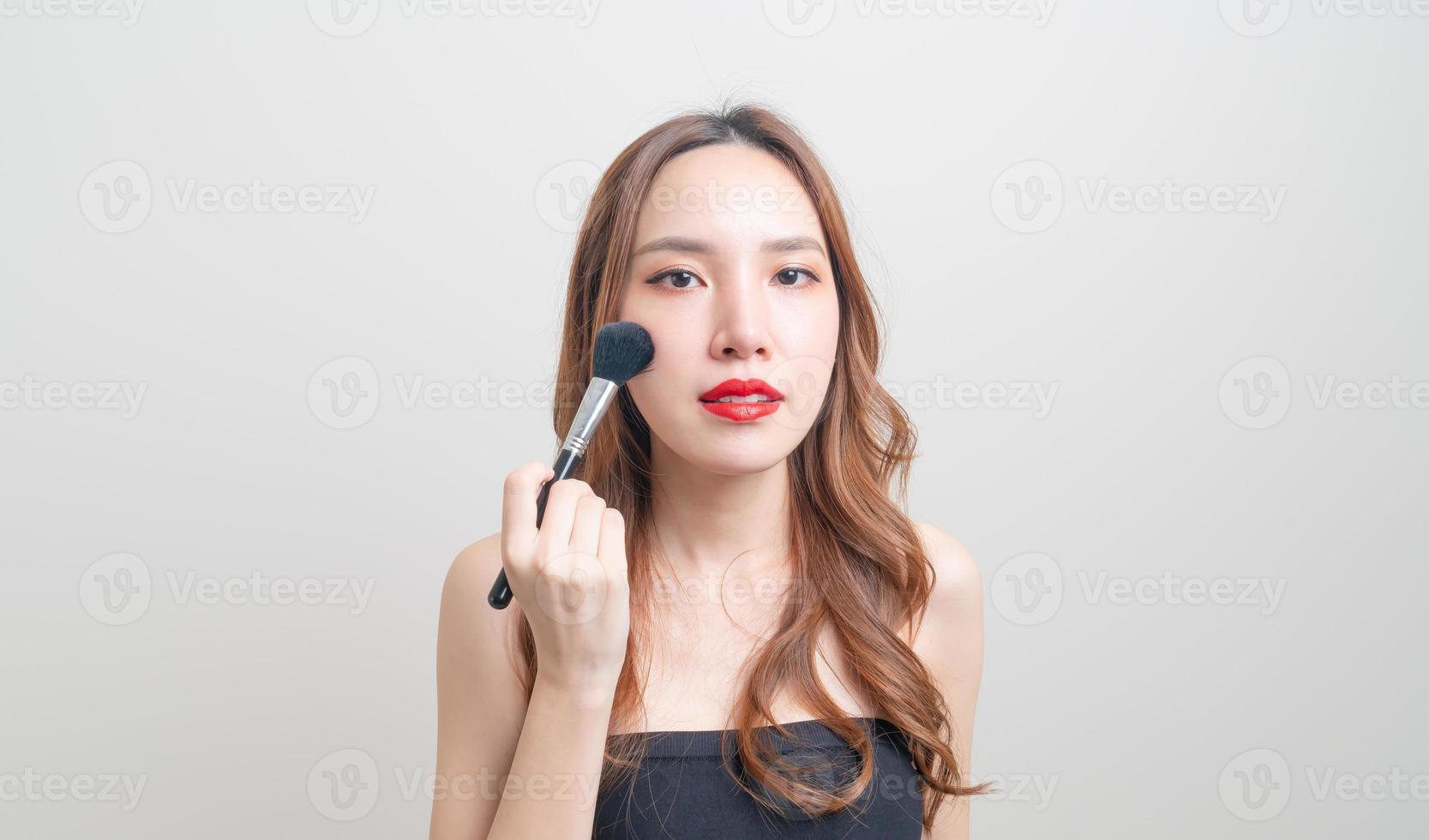 Retrato de mujer hermosa con pincel de maquillaje foto