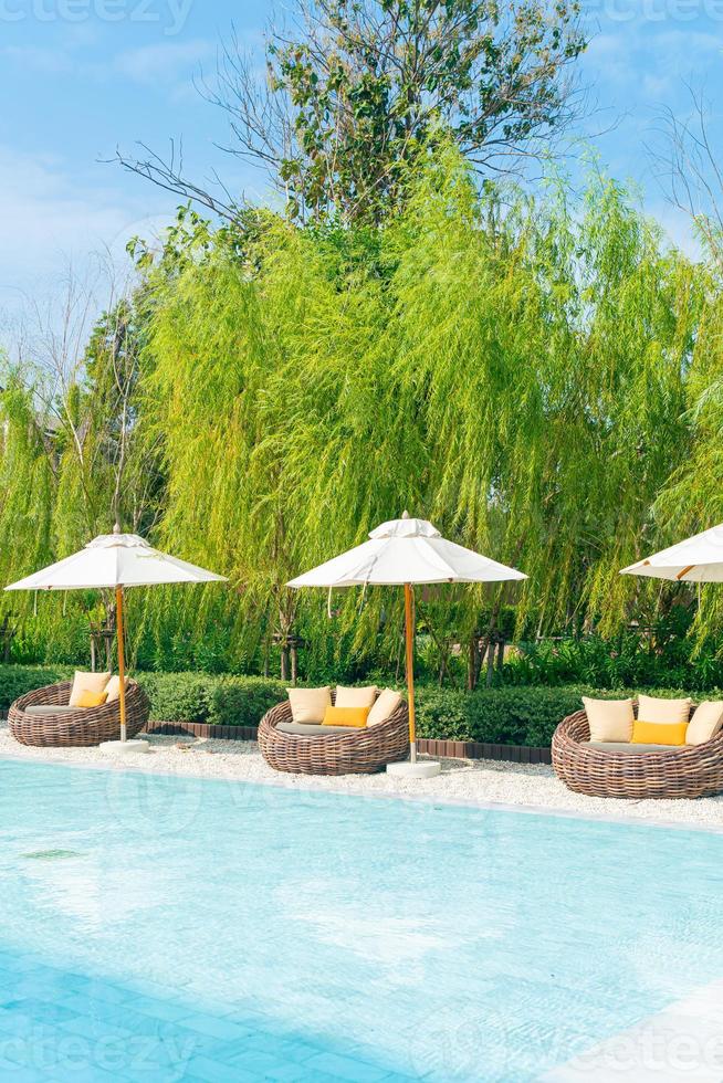 outdoor patio chair with pillow and umbrella around swimming pool photo