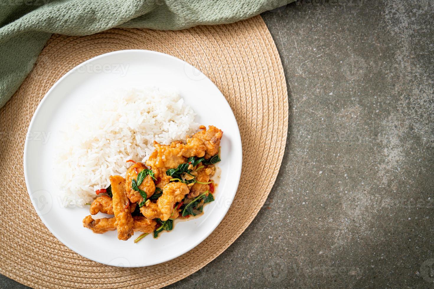 pescado frito salteado con albahaca y chile al estilo tailandés cubierto con arroz foto