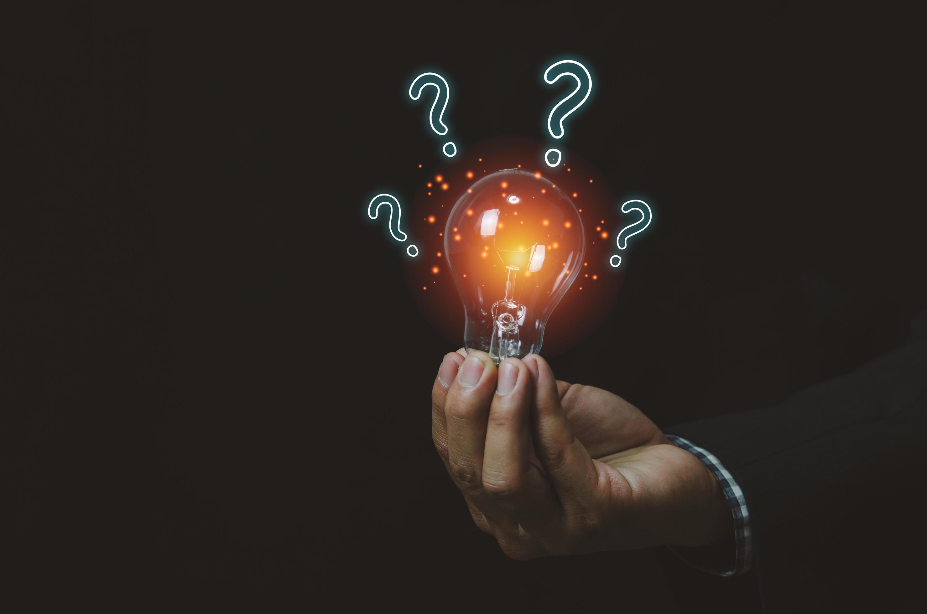 businessman holding a light bulb with question mark.Digital creative