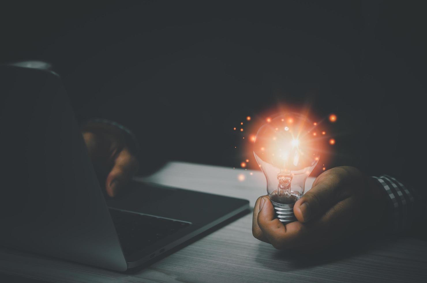businessman holding a light bulb with a laptop computer.Digital creative design concept technology marketing. photo