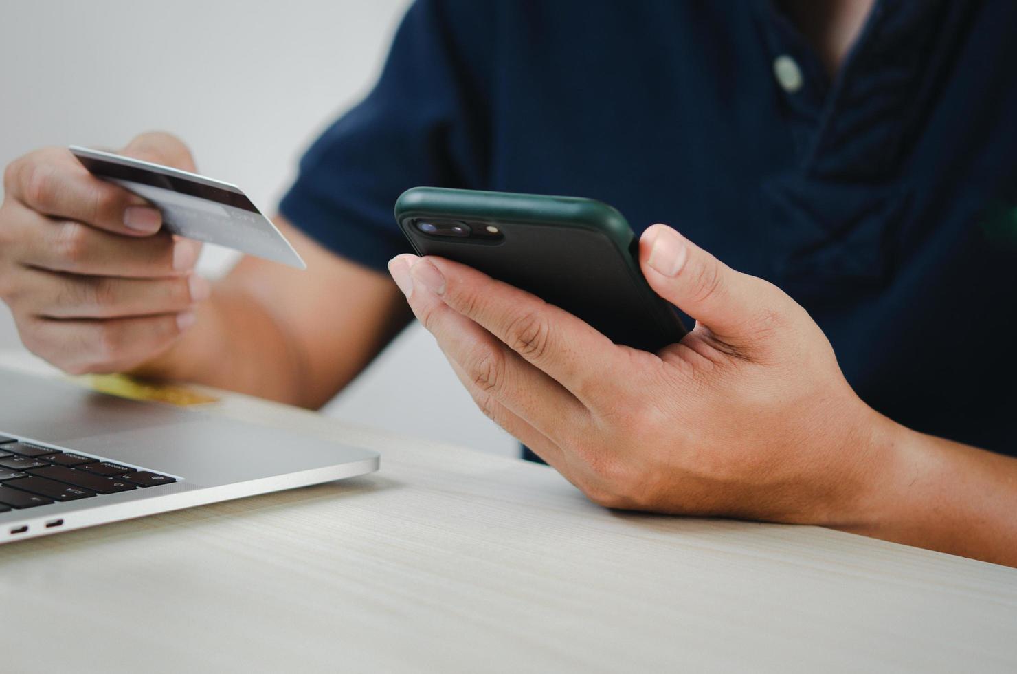 mano de hombre con tarjeta de crédito y teléfono móvil compras en línea comercio electrónico y banca por Internet. foto