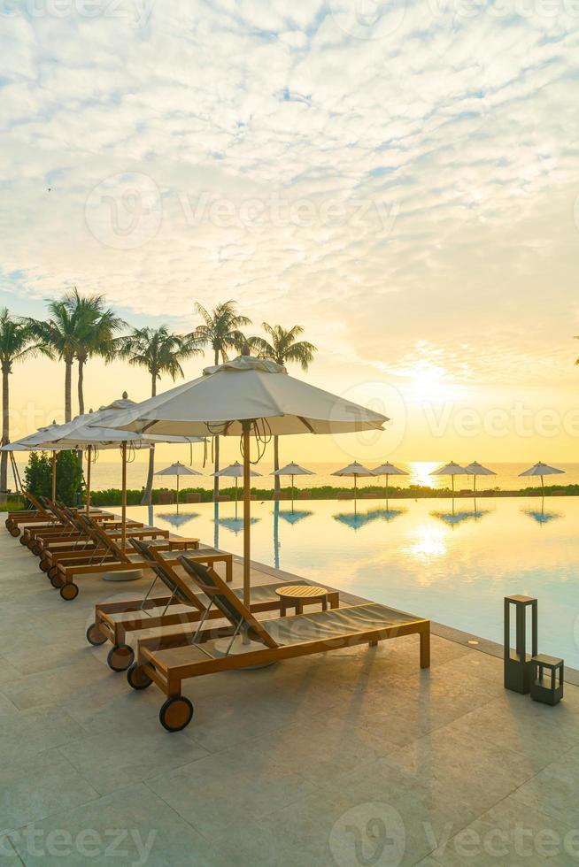 umbrella with bed pool around swimming pool with ocean sea background photo