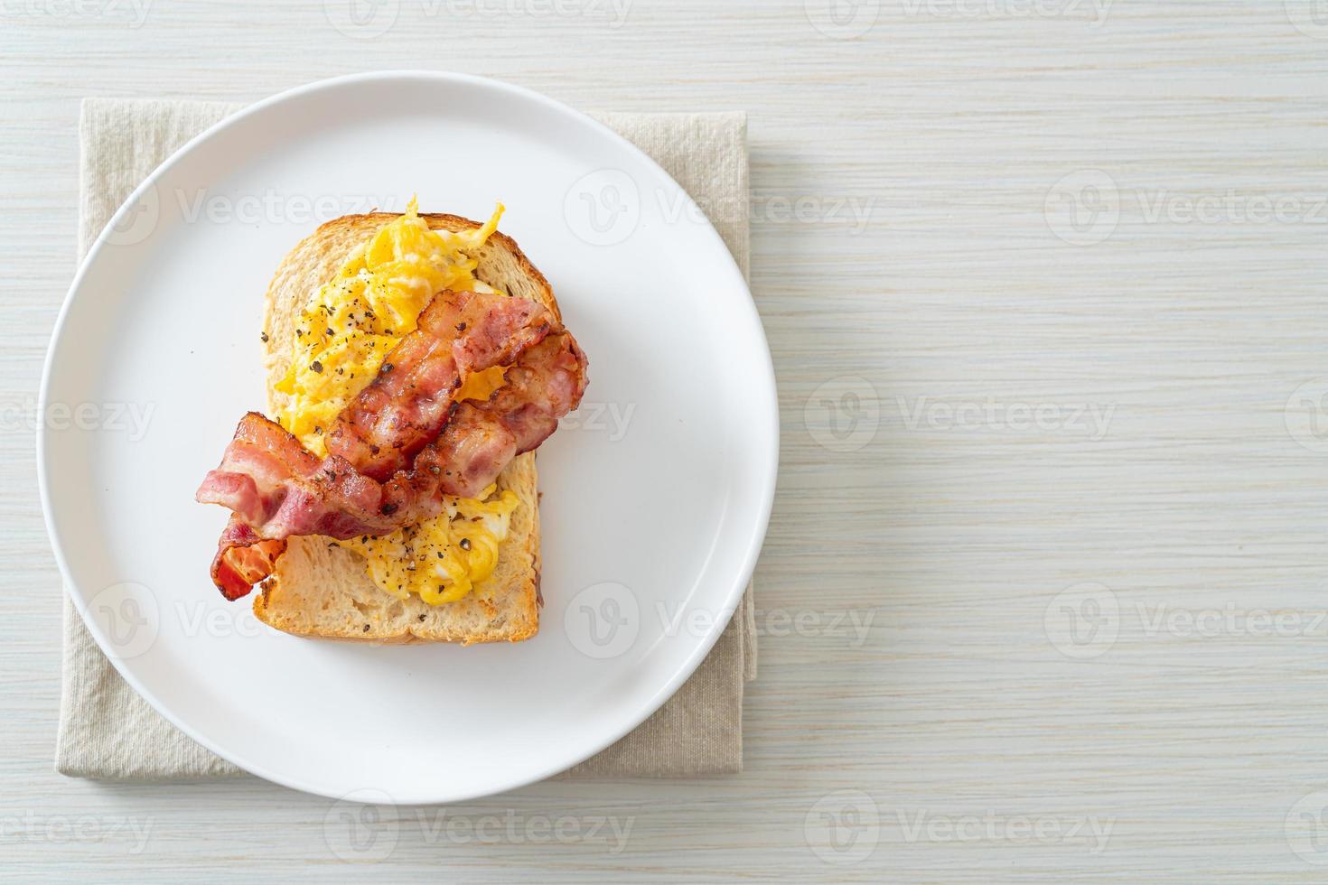 tostada de pan con huevos revueltos y tocino foto