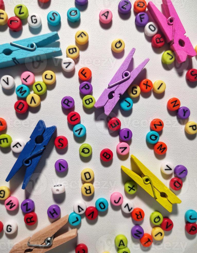 Colorful alphabet and number beads on white background photo
