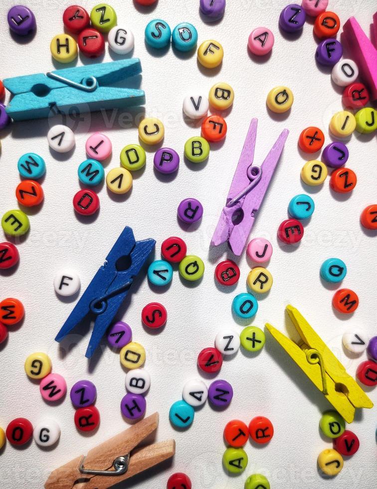 Colorful alphabet and number beads on white background photo