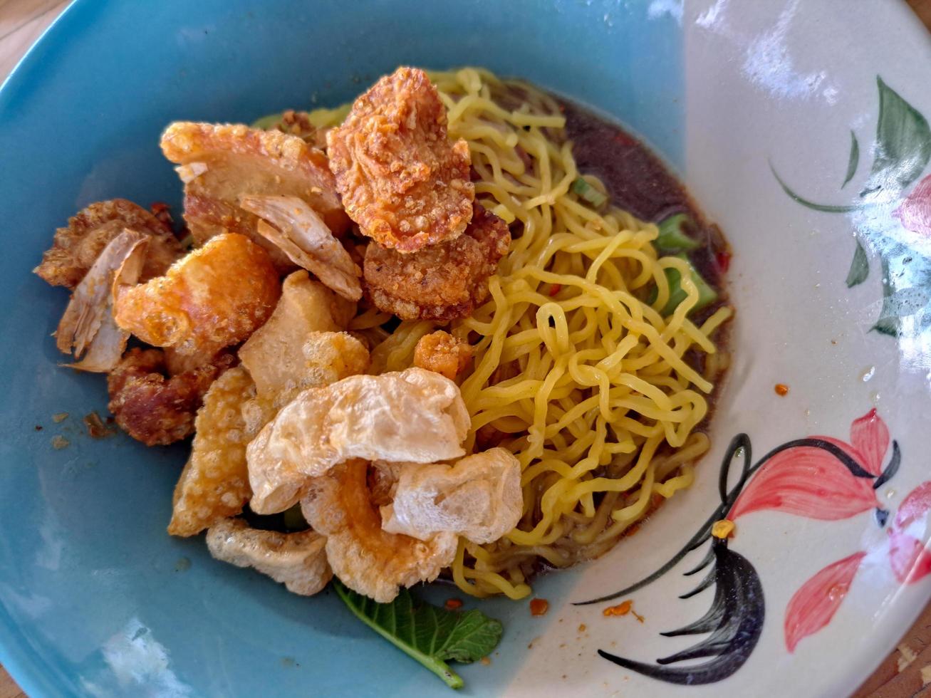 comida callejera en tailandia, fideos espolvoreados con piel de cerdo frita foto