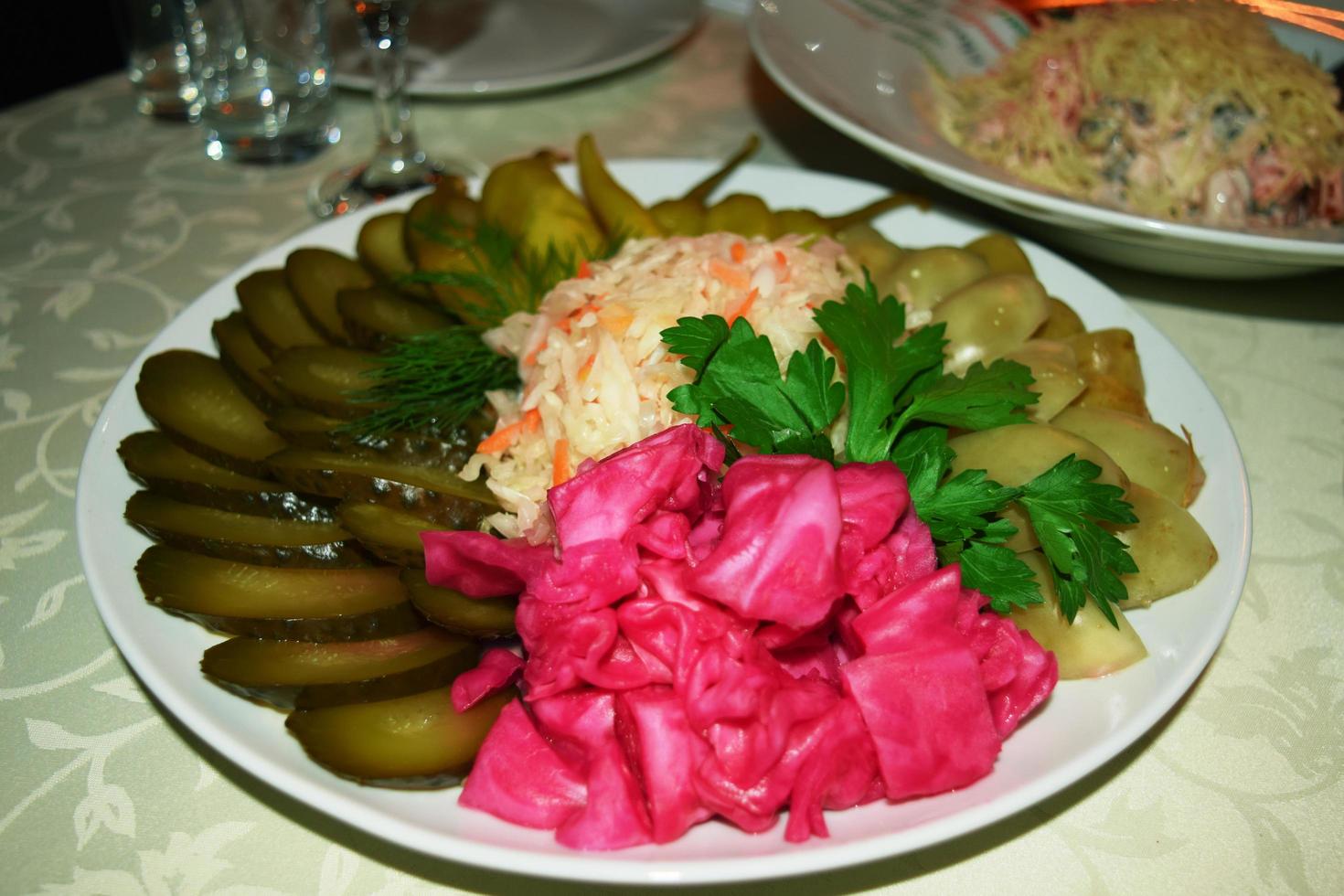 a plate with pickles - red cabbage, green tomato and cucumber photo