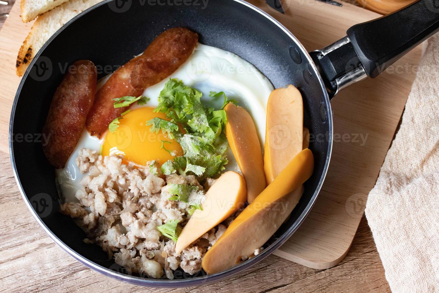 English breakfast with fried egg with minced pig and sausage Thai called kai Kara served in a small pan photo
