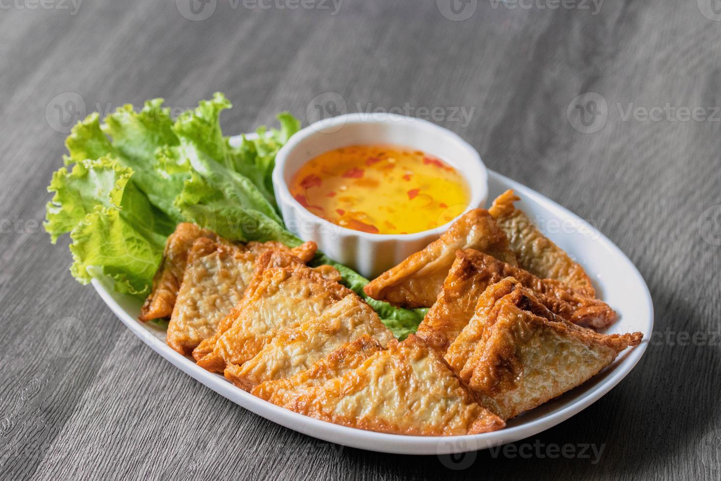 Triangular fried tofu eating with spicy dipping sauce, sweet and spicy photo