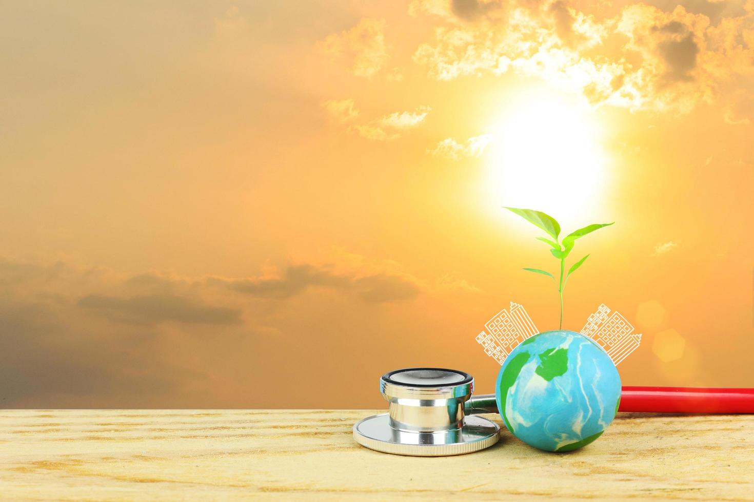 Happy earth day concept - Earth with plant growth and graphic of buildings against sunset light photo
