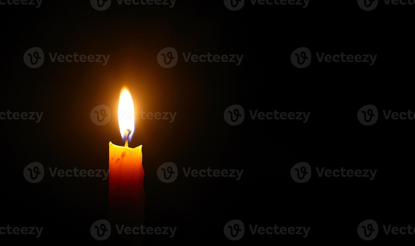 Yellow candle light burn against black background. Peace, Hope concept photo