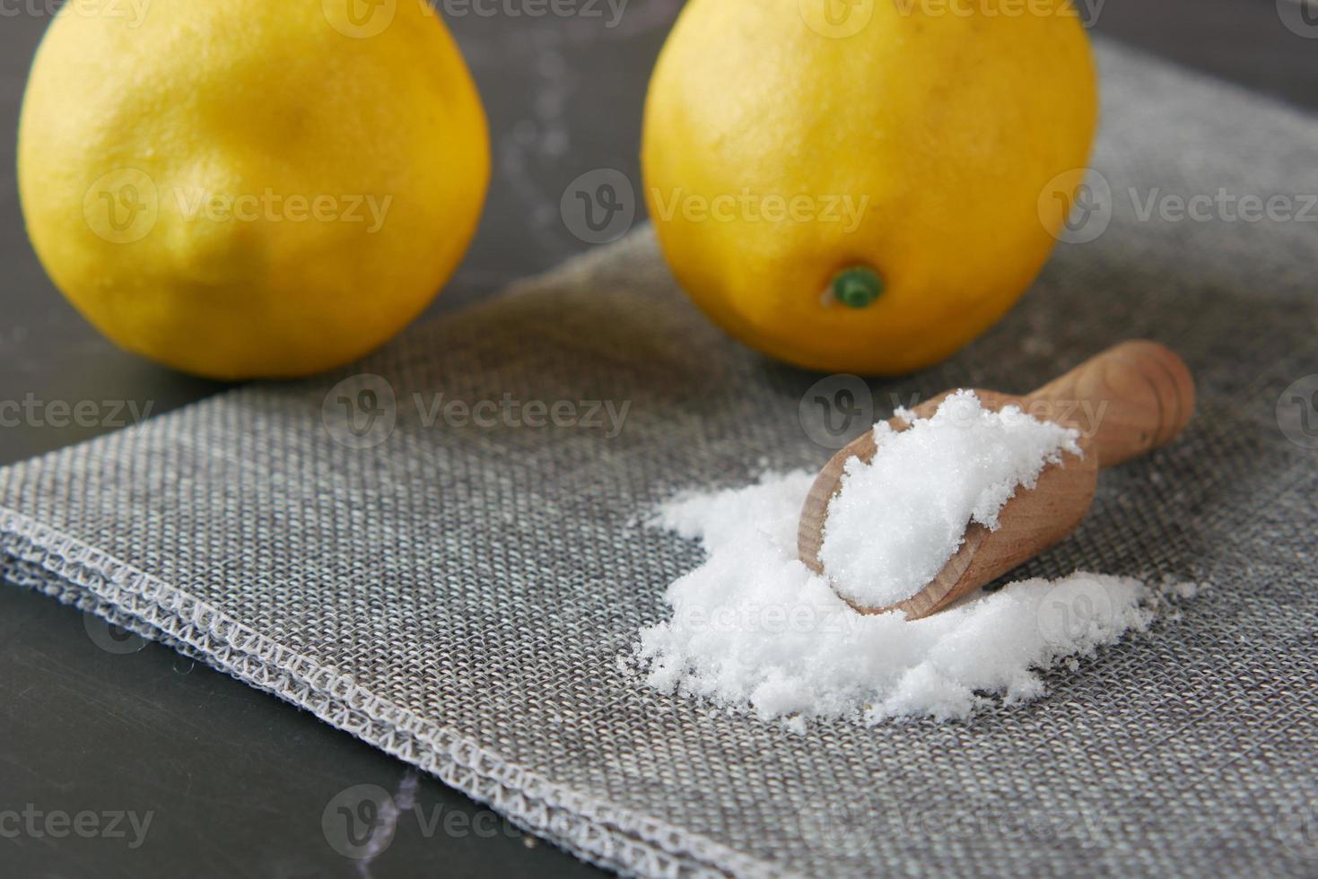 sal gruesa en una cuchara de madera y limón en la mesa foto