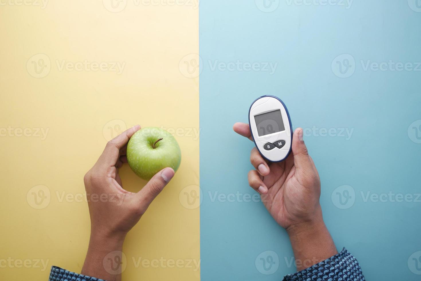sosteniendo herramientas de medición para diabéticos, manzana en la mesa foto