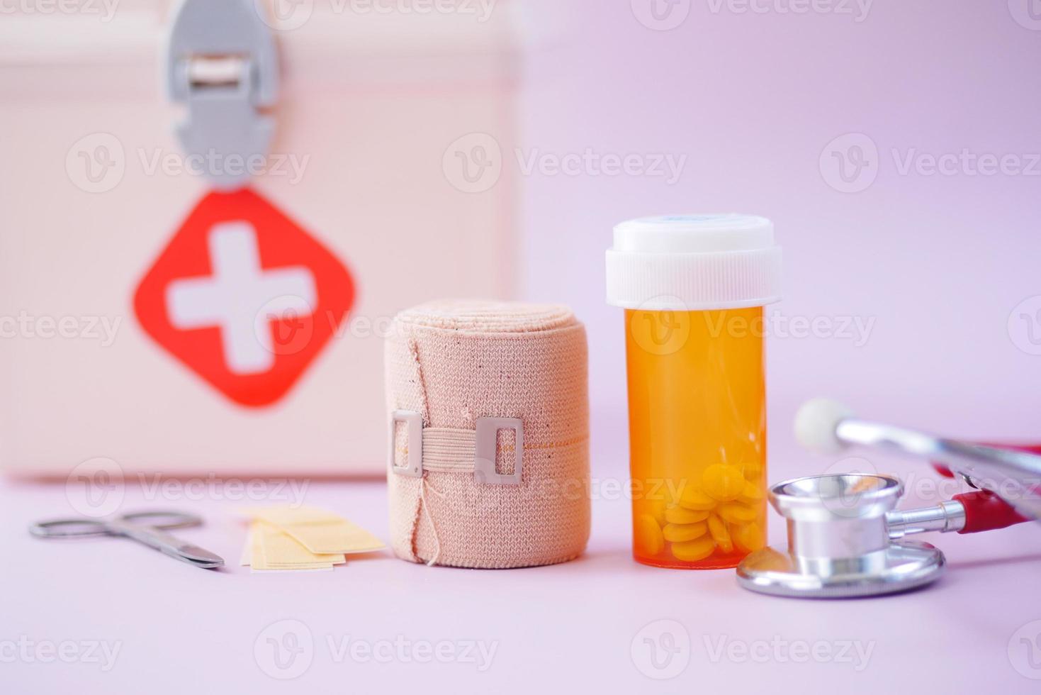 first aid kit box and medical pill on table photo