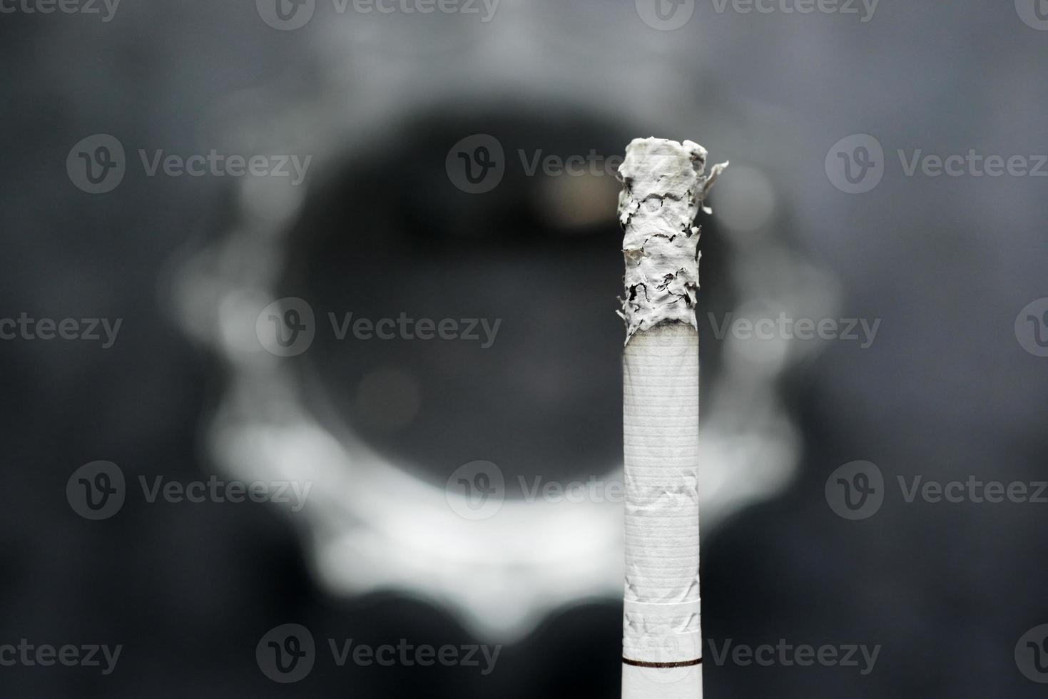 close up of burning cigarette on dark background photo