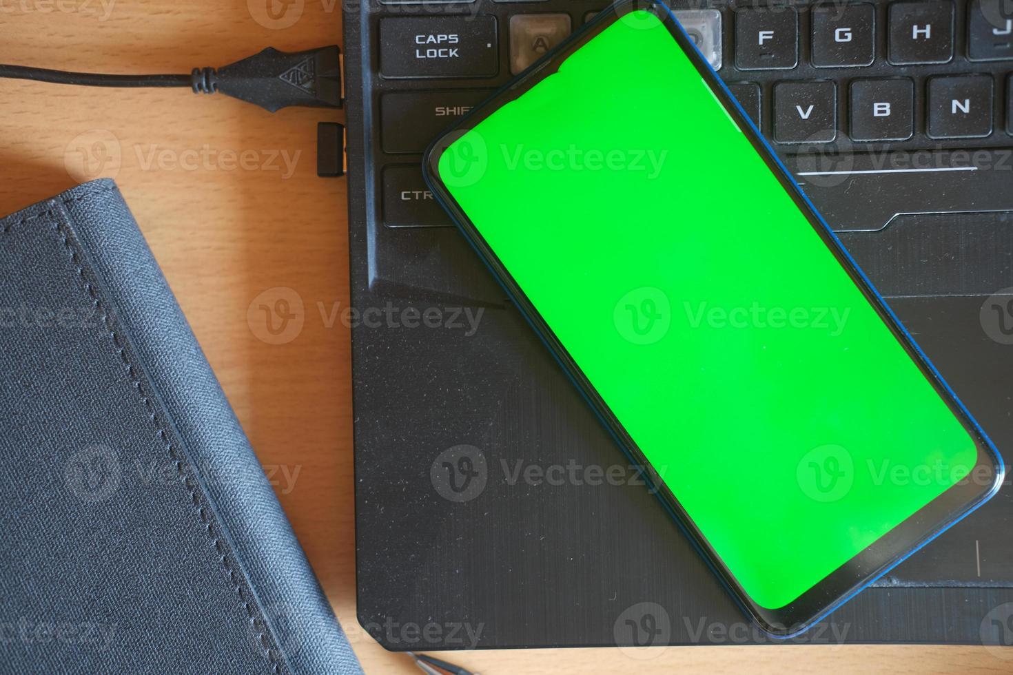 smart phone with empty screen, laptop on wooden background photo