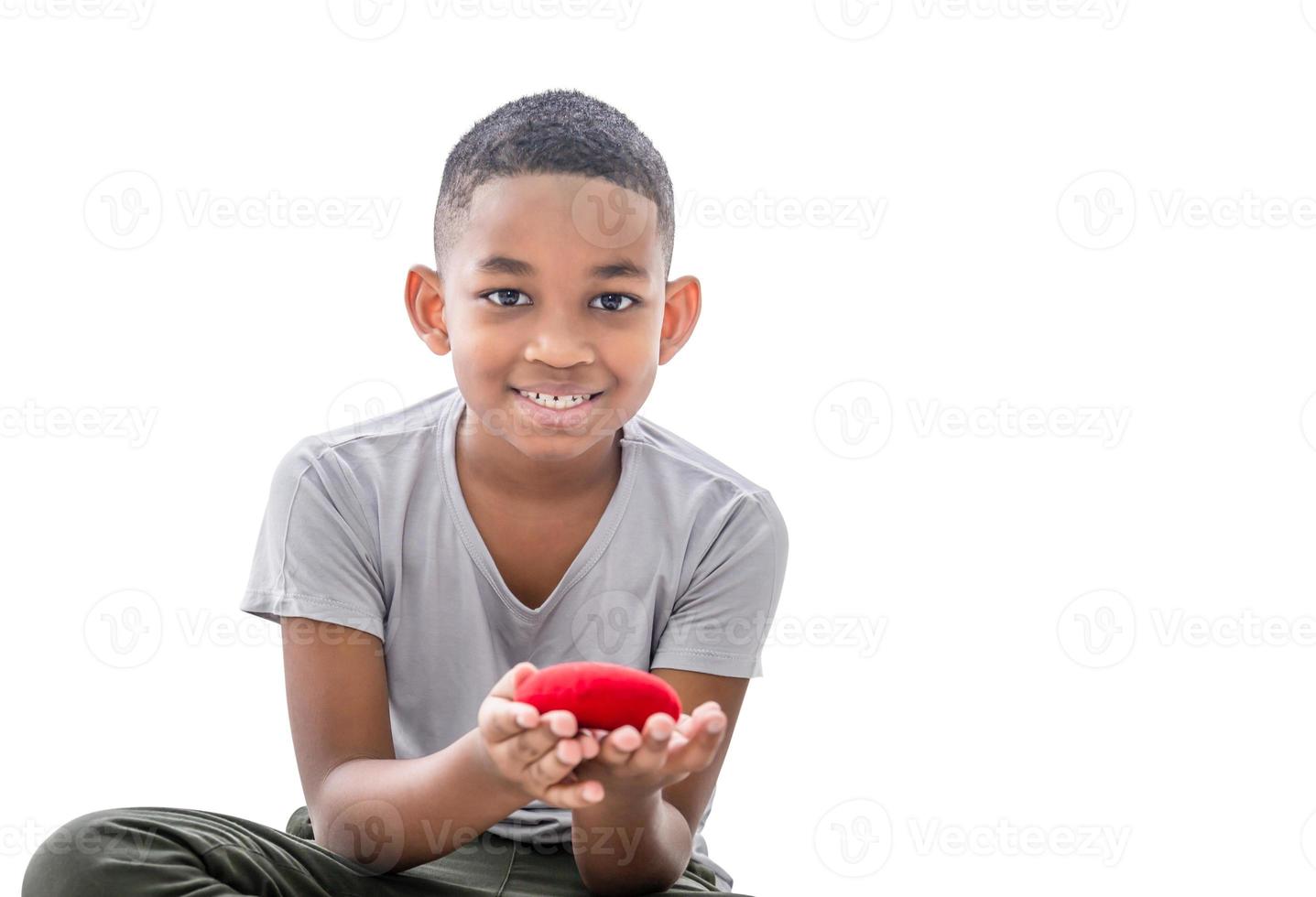 Smiling boy holding red heart shape with clipping path on white background photo