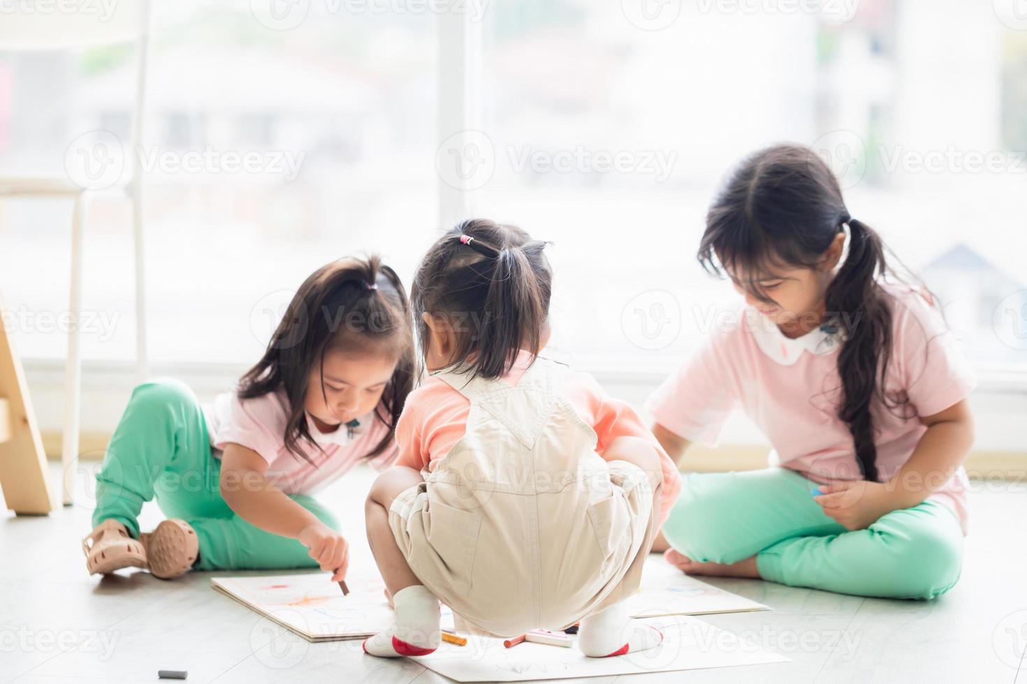 Children playing with their friends, Little girls mould from plasticine on the floor, Children playing toy and game in living room photo