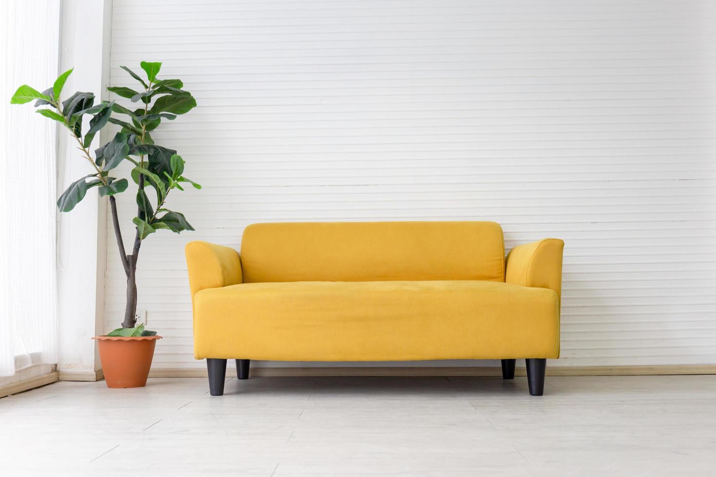 salón blanco interior con moderno sofá de tela amarilla con fondo de pared blanco vacío foto