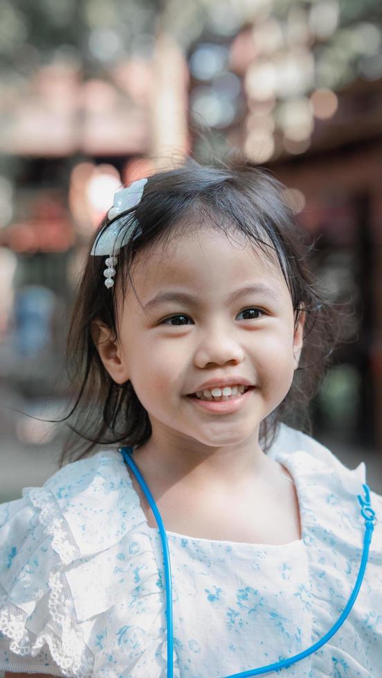 retrato de feliz y encantadora niña asiática de 4 años, pequeña niña preescolar con emoción de sonrisa en la cara foto